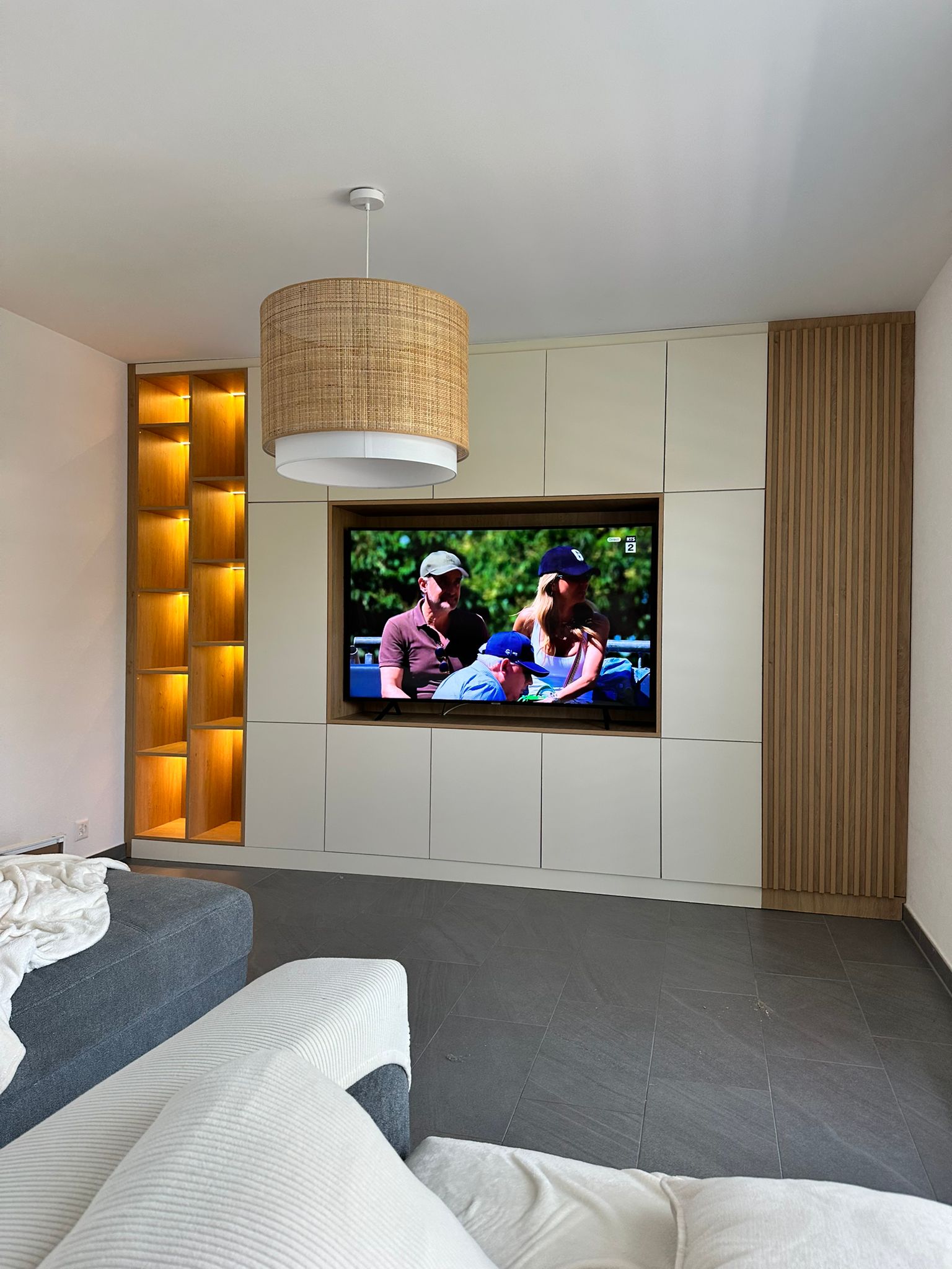 Meuble TV mural sur mesure avec étagères LED et tasseaux bois, agencement intérieur Vaud